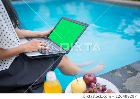 Working by the Pool Enjoying a Relaxing Laptop Lifestyle in a Beautiful, Serene Setting 120499297