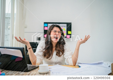 Excited Young Professional Celebrating Success in an Office Environment 120499308