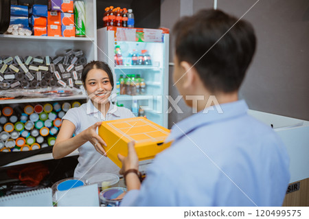 female staff hand over product male customer female staff hand over product male customer 120499575