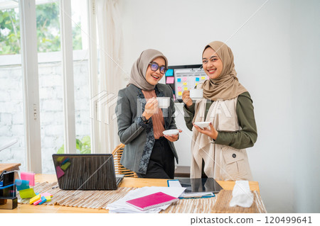 Women Enjoying a Delicious Coffee Beverage in a Stylish Modern Office Setting 120499641