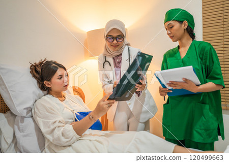 A dedicated medical team is diligently assisting a patient in a hospital room 120499663