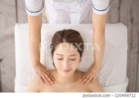Woman receiving a massage from an esthetician Woman receiving a massage from an esthetician 120499712