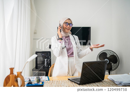 Professional Woman Engaged in a Phone Conversation at Modern Workspace 120499738