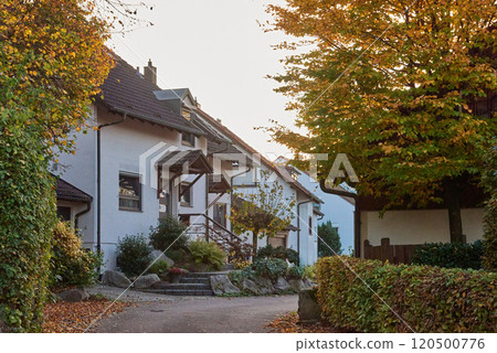 Charming House Beautifully Surrounded by Lush Greenery During the Lovely Autumn Season 120500776