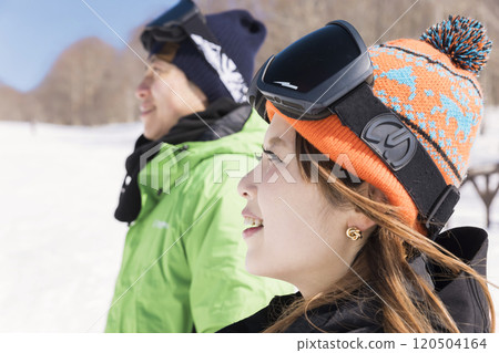 A man and a woman standing side by side on the slope looking at the scenery - Snowboarding image 120504164