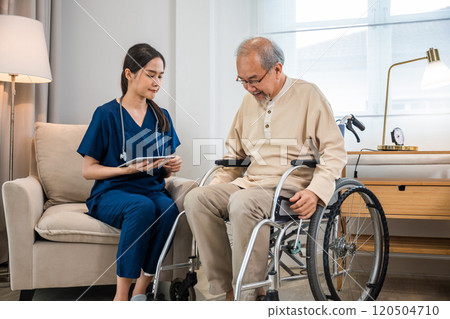 Asian woman doctor nursing holding digital tablet with patients chart while talking and explain for results of treatment to patient old man sitting in wheelchair, Health care and medical 120504710