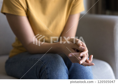 Young woman holding folded hands on lap 120505047