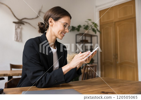 Businesswoman woman sit at workplace desk with smartphone Businesswoman woman sit at workplace desk with smartphone 120505065