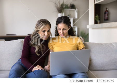 Young adult Hispanic daughter girl showing online application Young adult Hispanic daughter girl showing online application 120505079