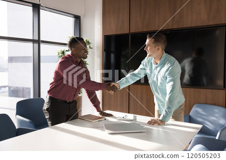 Confident positive male business leaders shaking hands with support 120505203