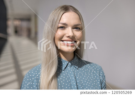 Happy beautiful blonde business professional woman standing in hallway alone Happy beautiful blonde business professional woman standing in hallway alone 120505269