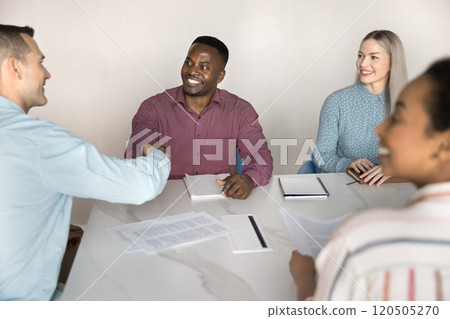 Diverse male business partners shaking hands at large office table Diverse male business partners shaking hands at large office table 120505270