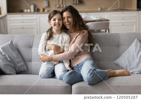 Laughing woman cuddling her little cute daughter 120505287