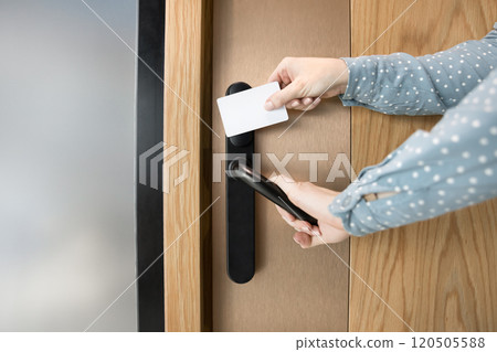 Cropped shot of female hands opening door with key card Cropped shot of female hands opening door with key card 120505588