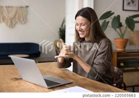 Woman interacting using laptop, video call application and sign language Woman interacting using laptop, video call application and sign language 120505663