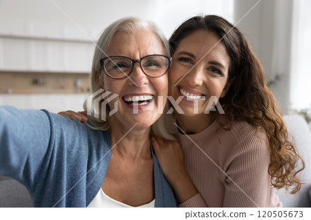 Older woman her young adult daughter laughing, looking at camera 120505673