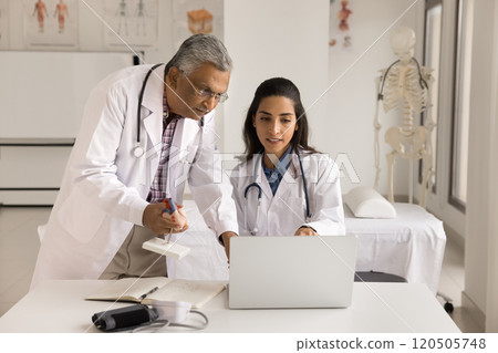 Two multiethnic colleagues discuss patient disease diagnose 120505748