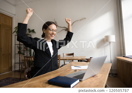 Happy businesswoman get news, raises her arms in celebratory gesture Happy businesswoman get news, raises her arms in celebratory gesture 120505787