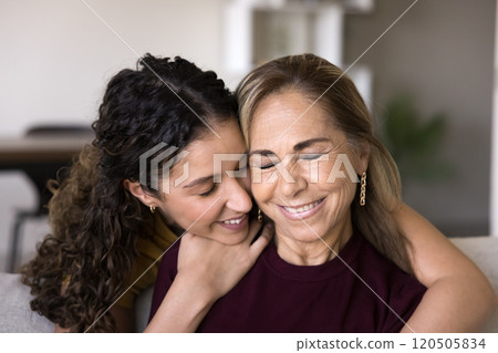 Happy young daughter woman embracing mature Hispanic mother 120505834