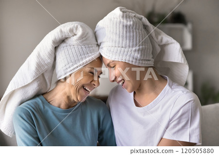 Cheerful mature mom and daughter in head towels enjoying spa Cheerful mature mom and daughter in head towels enjoying spa 120505880