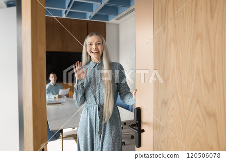 Happy beautiful young business professional woman opening meeting room door 120506078