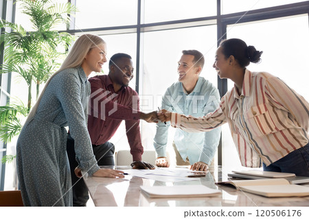 Happy diverse business colleagues giving fist bump over large table 120506176