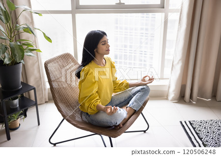 Peaceful young Indian woman meditating at home Peaceful young Indian woman meditating at home 120506248
