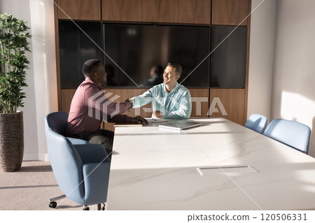 Two successful multiethnic business men shaking hands in office Two successful multiethnic business men shaking hands in office 120506331