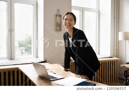 Portrait of young office manager posing standing at workplace Portrait of young office manager posing standing at workplace 120506557