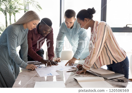 Focused busy multiethnic project managers discussing marketing reports Focused busy multiethnic project managers discussing marketing reports 120506569