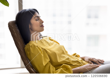 Calm sleepy beautiful young Indian woman resting on lounge chair Calm sleepy beautiful young Indian woman resting on lounge chair 120506690