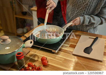 Young woman preparing homemade pasta dish in kitchen during the holiday season Young woman preparing homemade pasta dish in kitchen during the holiday season 120506967