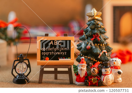 A holiday scene featuring a miniature chalkboard and Christmas tree 120507731