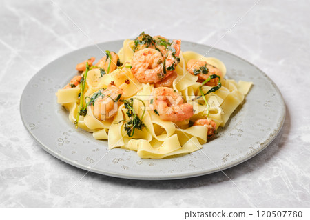 Delicious shrimp and pasta dish garnished with herbs served on a decorative plate Delicious shrimp and pasta dish garnished with herbs served on a decorative plate 120507780