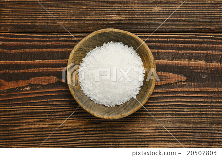 A close-up view of coarse salt in a wooden bowl on rustic wooden table A close-up view of coarse salt in a wooden bowl on rustic wooden table 120507803