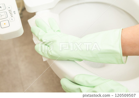 The hands of a middle-aged woman wiping the toilet The hands of a middle-aged woman wiping the toilet 120509507