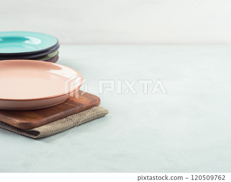 Arrangement of colorful plates stacked on wooden board 120509762