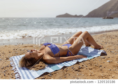 Beautiful woman with beach towel on sand near sea Beautiful woman with beach towel on sand near sea 120510186