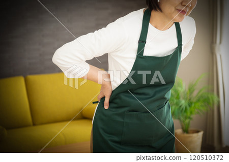 穿著圍裙患有背痛的中年婦女 120510372