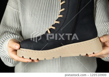 Leather winter boot in hands. High-quality fashionable shoes 120510900