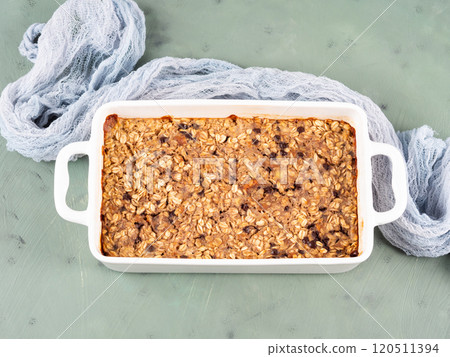 Oatmeal porridge granola cake in white baking tray on green Oatmeal porridge granola cake in white baking tray on green 120511394