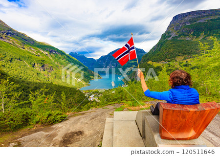 Tourist over Geirangerfjord holds norwegian flag Tourist over Geirangerfjord holds norwegian flag 120511646