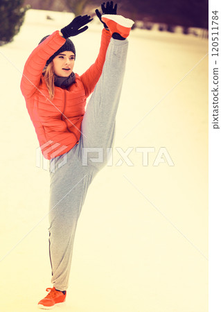 Woman wearing sportswear exercising outside during winter 120511784