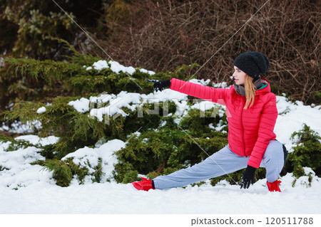 Woman wearing sportswear exercising outside during winter 120511788