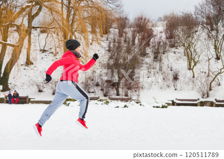 Woman wearing sportswear exercising outside during winter Woman wearing sportswear exercising outside during winter 120511789