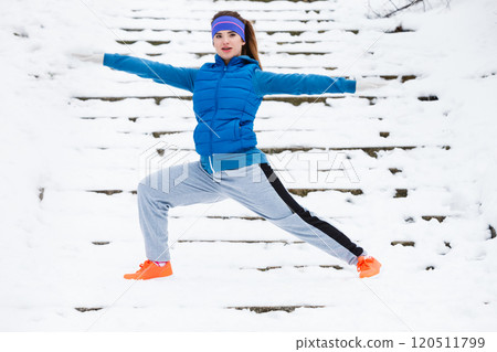 Woman wearing sportswear exercising outside during winter Woman wearing sportswear exercising outside during winter 120511799