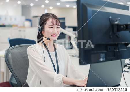 在呼叫中心回覆客戶的女接線生 在呼叫中心回覆客戶的女接線生 120512226