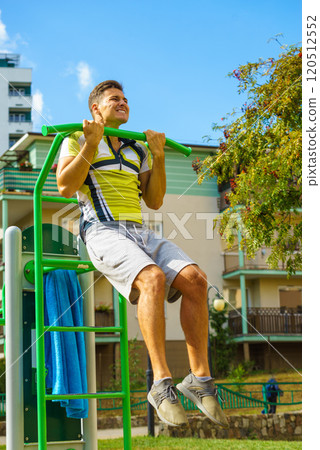 Man doing pull ups in outdoor gym 120512552