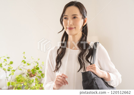 Woman carrying a bag on her shoulder indoors Woman carrying a bag on her shoulder indoors 120512662