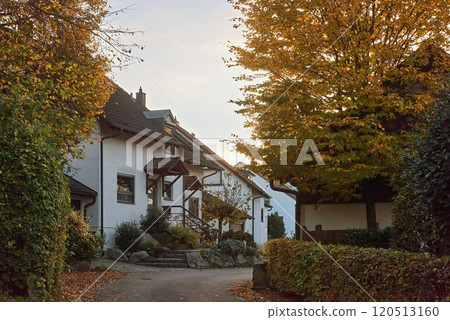 Charming House Beautifully Surrounded by Lush Greenery During the Lovely Autumn Season 120513160